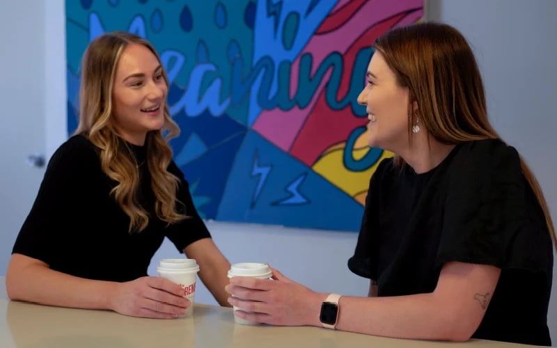 Altius Group two women share a coffee